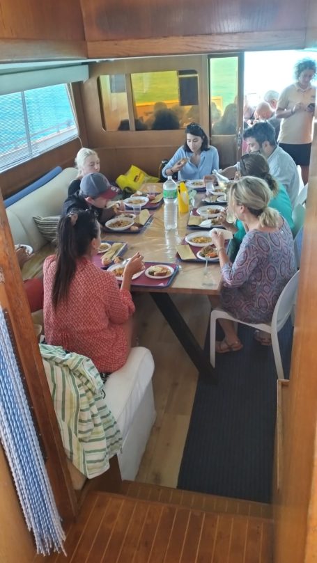 Group of people gathered around a table, enjoying a meal together indoors.
